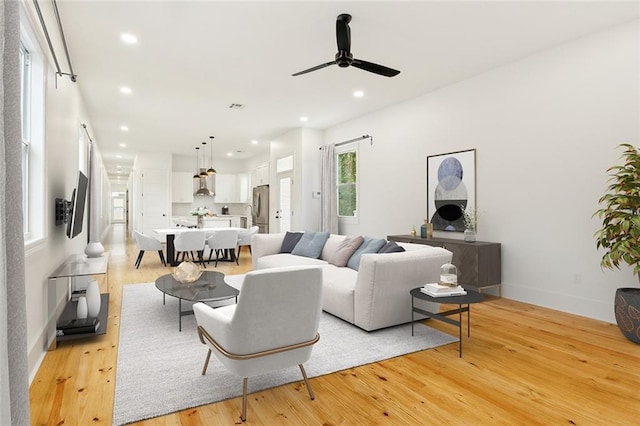 living room featuring light wood-type flooring and ceiling fan