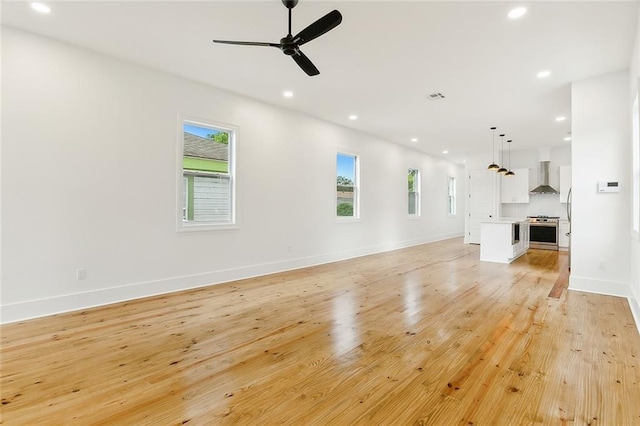 unfurnished living room featuring ceiling fan and light wood-type flooring