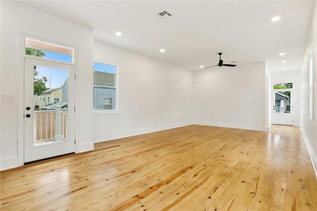 spare room with ceiling fan, a healthy amount of sunlight, and light wood-type flooring