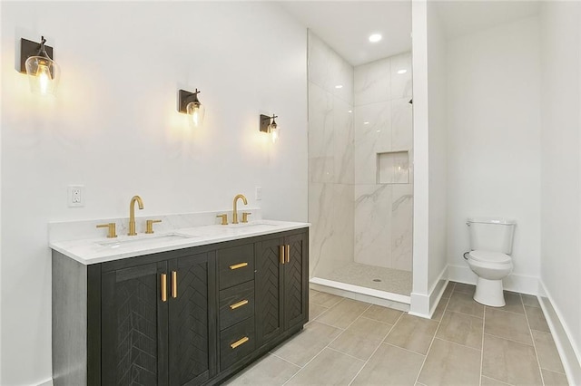 bathroom featuring a tile shower, vanity, and toilet