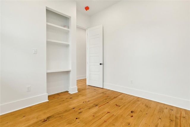 unfurnished bedroom featuring a closet and hardwood / wood-style flooring