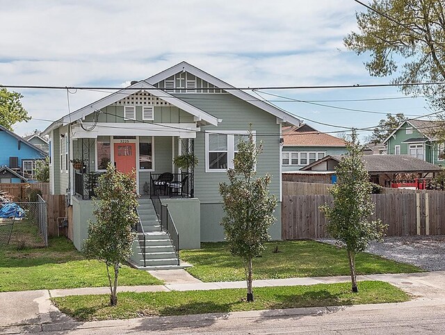 view of front of home featuring covered porch and a front lawn