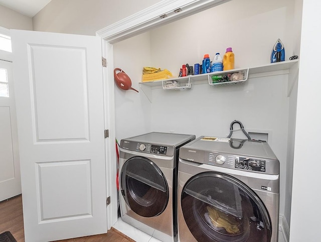 washroom featuring wood-type flooring and washing machine and clothes dryer