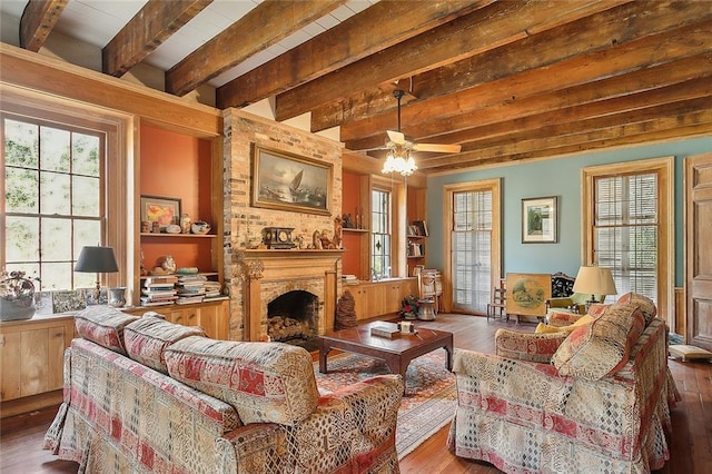 living room with ceiling fan, a fireplace, hardwood / wood-style flooring, and beamed ceiling