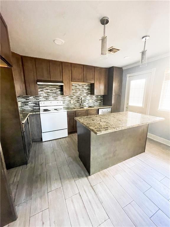 kitchen featuring a kitchen island, white electric range, sink, light stone counters, and crown molding