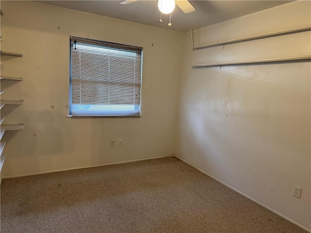 carpeted spare room with ceiling fan