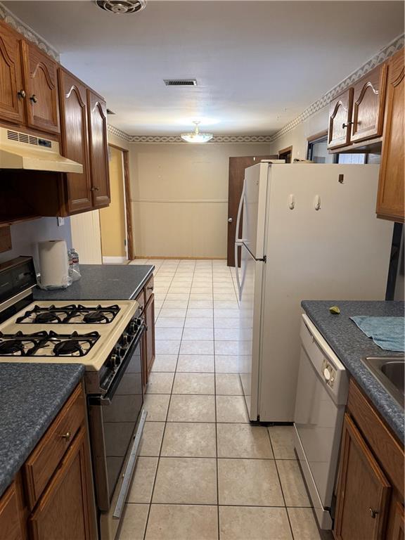 kitchen with sink, white appliances, and light tile patterned floors