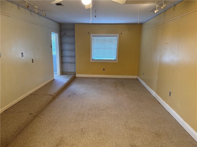 carpeted empty room with ceiling fan and rail lighting