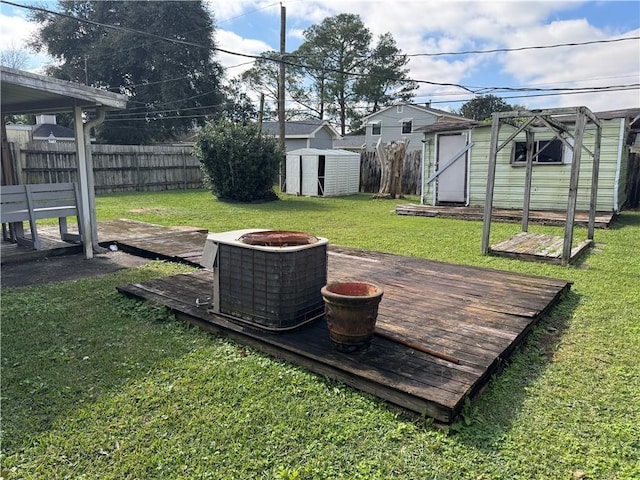 view of yard with a deck, an outdoor fire pit, central AC, and a shed