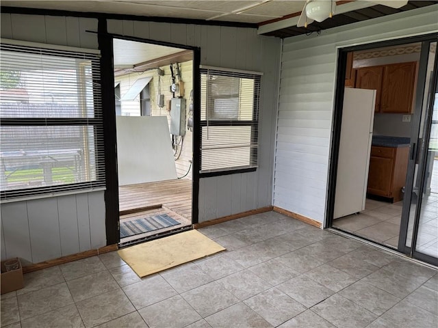 756 Mystic Ave, Gretna, LA 70056 - interior space with light tile patterned flooring, a ceiling fan, wood walls, and baseboards