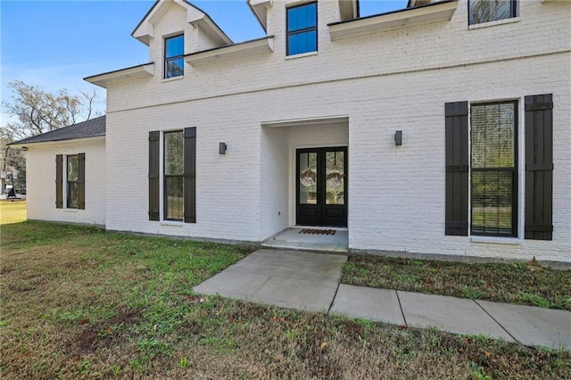 view of exterior entry with a yard