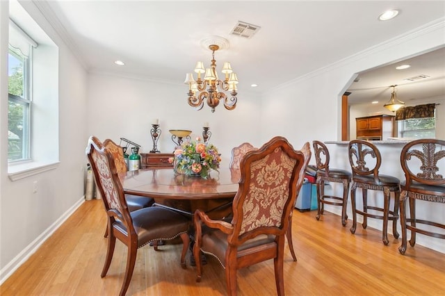 dining space featuring a notable chandelier, crown molding, and light hardwood / wood-style floors