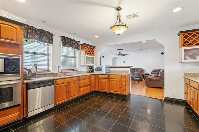 kitchen featuring crown molding, appliances with stainless steel finishes, sink, and decorative light fixtures