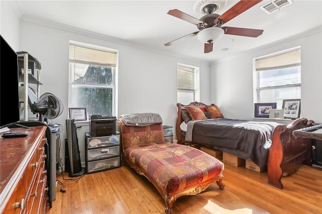 bedroom with ceiling fan, crown molding, multiple windows, and light hardwood / wood-style floors