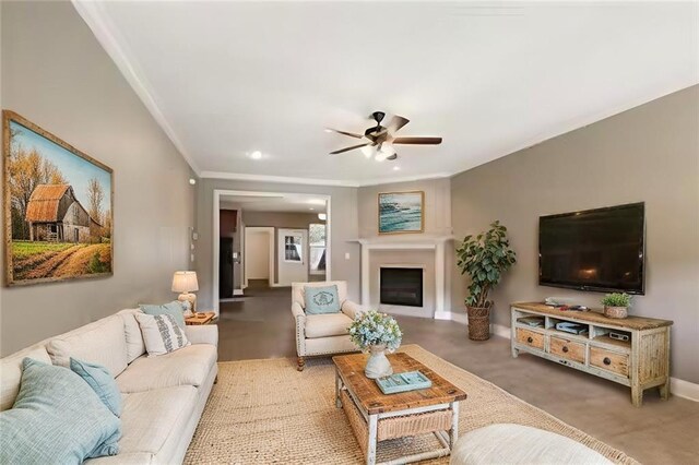 living room with ceiling fan, ornamental molding, and carpet floors