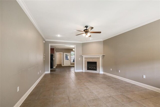 unfurnished living room with crown molding, a tile fireplace, light tile patterned floors, and ceiling fan