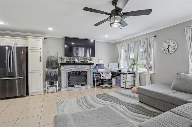 living room with ceiling fan, light tile patterned floors, a high end fireplace, and crown molding