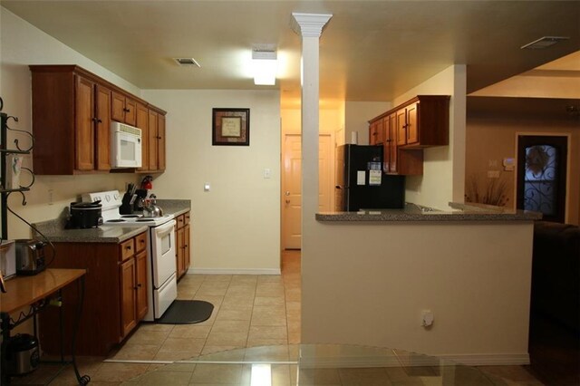 kitchen with decorative columns, light tile patterned flooring, kitchen peninsula, and white appliances