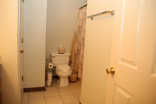 bathroom with toilet and tile patterned flooring