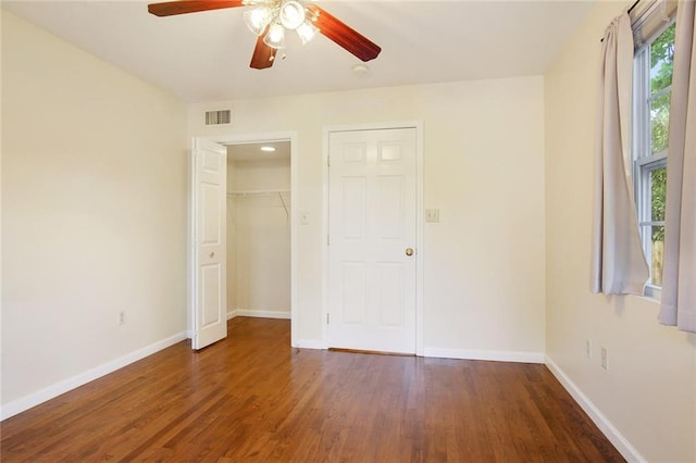 unfurnished bedroom with ceiling fan, dark hardwood / wood-style floors, and a closet