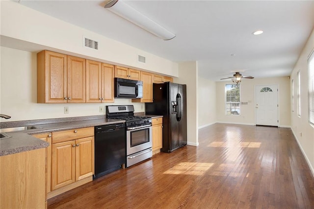 kitchen with black appliances, ceiling fan, dark hardwood / wood-style floors, and sink