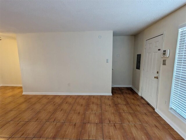 unfurnished room with a textured ceiling and light hardwood / wood-style floors