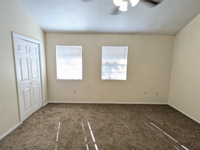 spare room with baseboards, a textured ceiling, ceiling fan, and carpet flooring