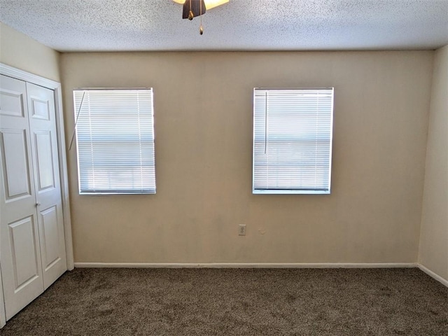 carpeted empty room with ceiling fan, a textured ceiling, and baseboards