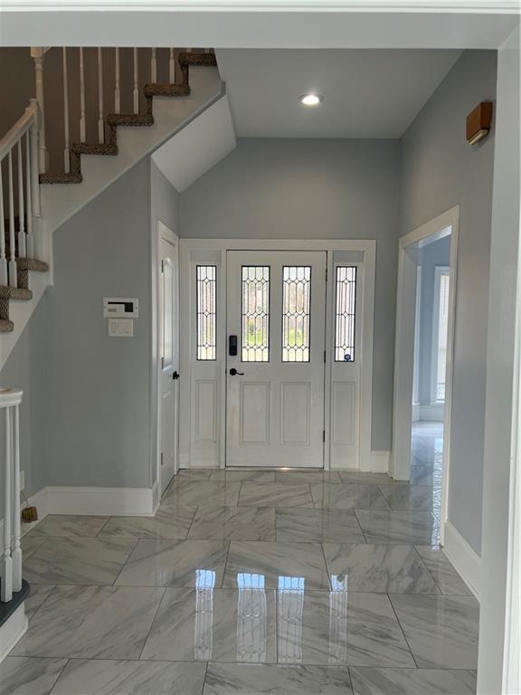 entrance foyer featuring recessed lighting, marble finish floor, stairway, and baseboards