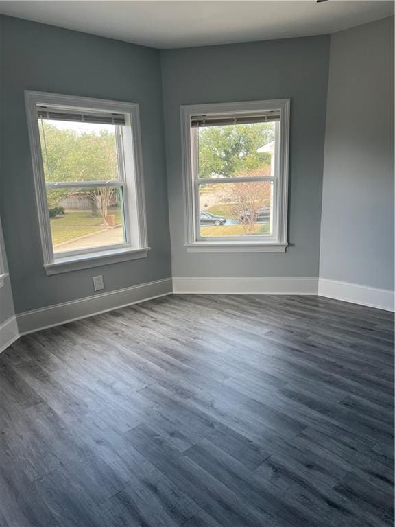 empty room featuring dark wood-style floors and baseboards