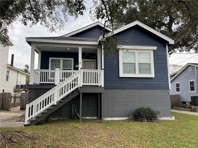 view of front facade featuring cooling unit, a porch, and a front yard