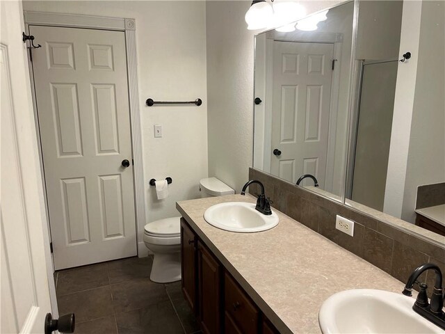 bathroom featuring backsplash, toilet, vanity, and tile patterned flooring