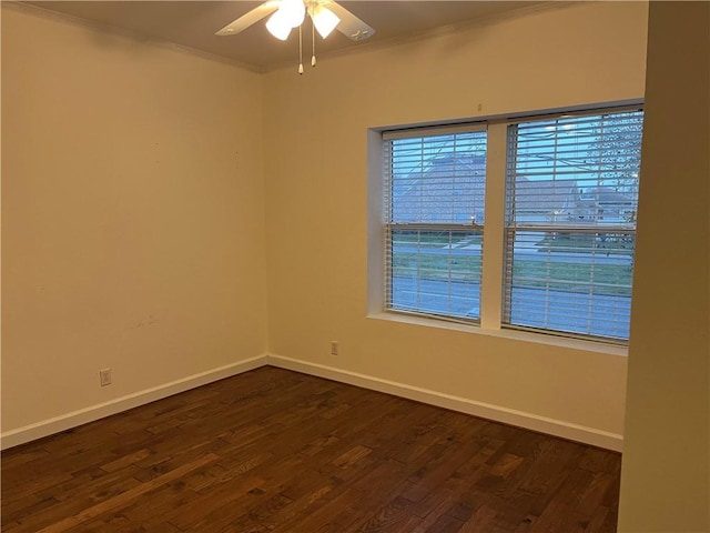 spare room featuring ceiling fan, dark wood-type flooring, and crown molding