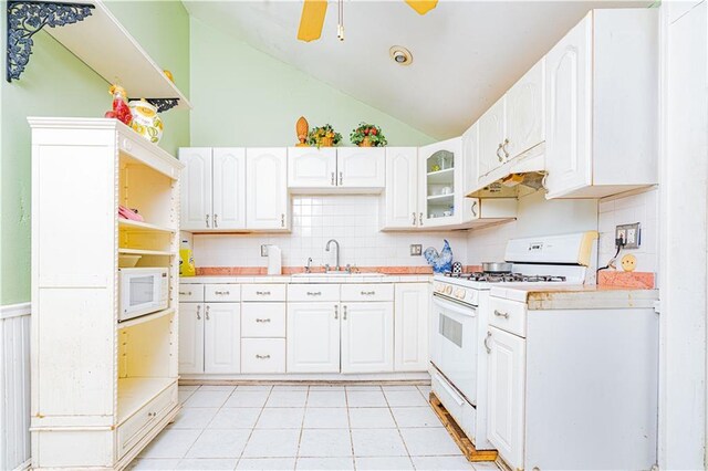 kitchen with lofted ceiling, ceiling fan, sink, white appliances, and white cabinetry