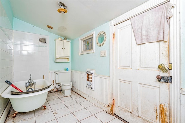 bathroom featuring lofted ceiling, tile patterned flooring, a tub to relax in, toilet, and heating unit