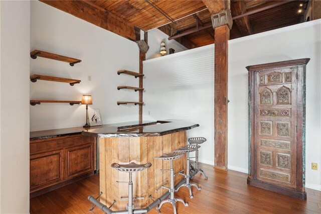 bar featuring dark hardwood / wood-style flooring, wood ceiling, and beam ceiling