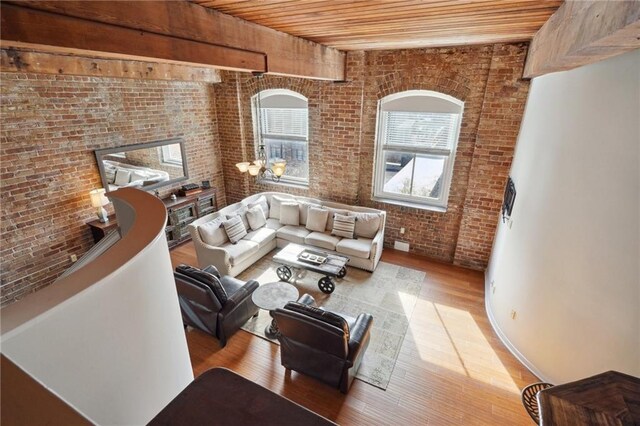 living room featuring light hardwood / wood-style floors, wooden ceiling, and brick wall