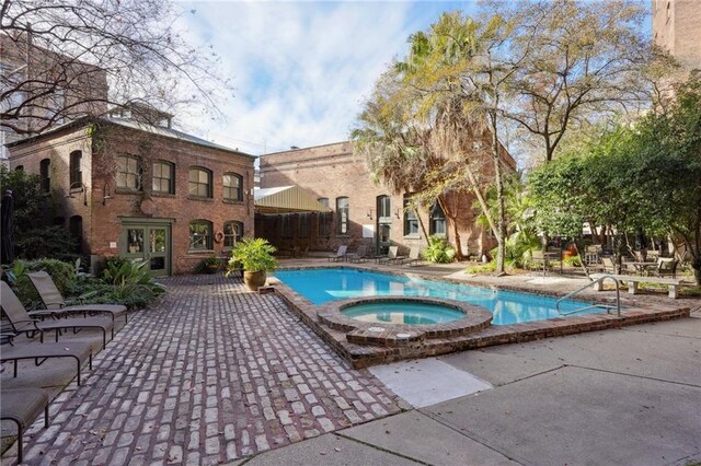 view of swimming pool with an in ground hot tub and a patio