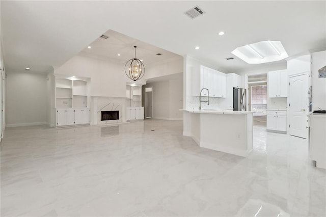 interior space with a high end fireplace, sink, crown molding, and a notable chandelier