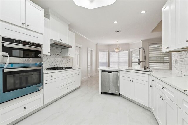 kitchen with appliances with stainless steel finishes, white cabinetry, decorative light fixtures, and tasteful backsplash