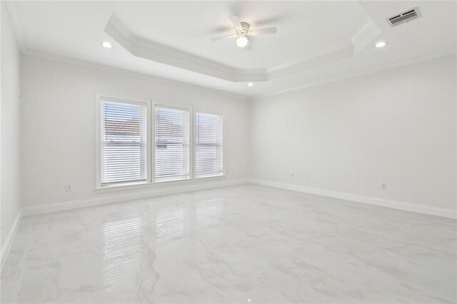 spare room featuring ceiling fan, ornamental molding, and a raised ceiling