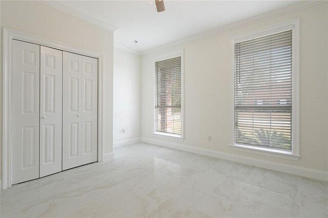 unfurnished bedroom with ceiling fan, ornamental molding, a closet, and multiple windows