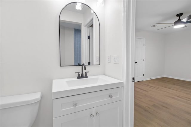 bathroom featuring hardwood / wood-style flooring, ceiling fan, vanity, and toilet