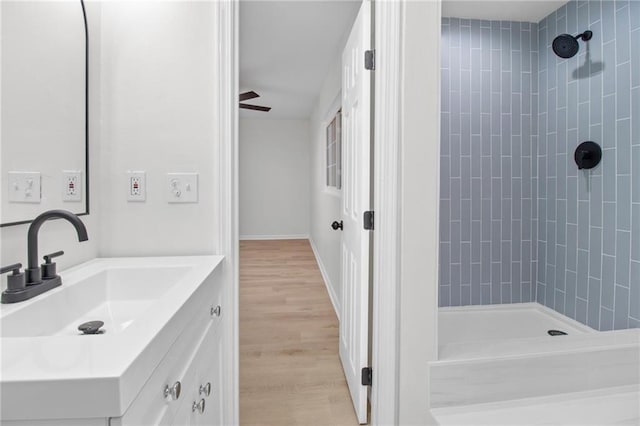 bathroom with vanity, tiled shower, and hardwood / wood-style floors