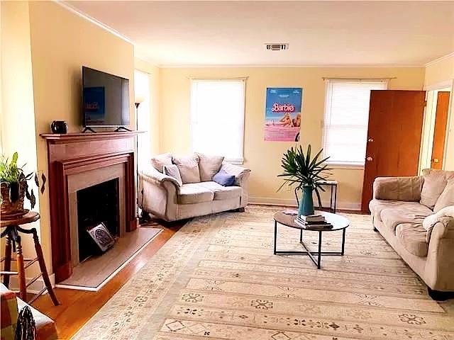 living room featuring crown molding and hardwood / wood-style floors