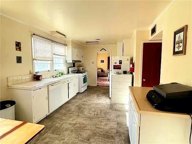 kitchen with white cabinets, ventilation hood, white appliances, and ornamental molding