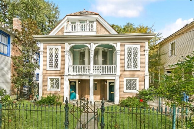 view of front of home with a balcony and a front lawn