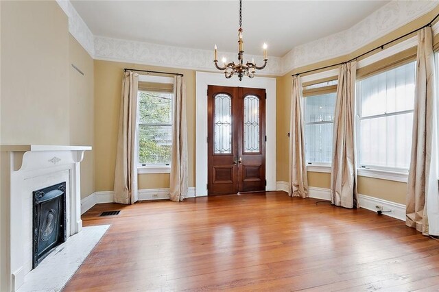 entryway with light hardwood / wood-style floors and a chandelier