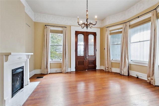 7917 Sycamore St, New Orleans, LA 70118 - foyer with hardwood / wood-style floors, a chandelier, baseboards, and a fireplace with flush hearth