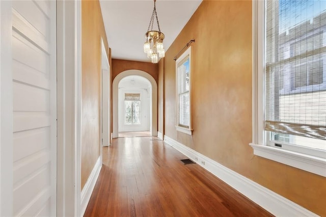 doorway to outside featuring wood-type flooring and a chandelier